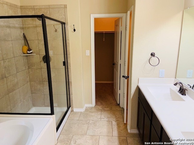 bathroom featuring plus walk in shower, vanity, and tile patterned floors