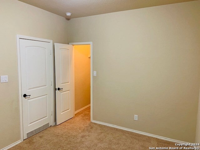 unfurnished bedroom featuring light colored carpet