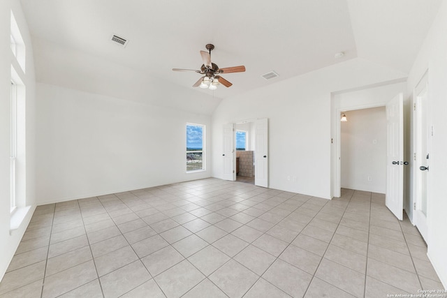 tiled spare room featuring vaulted ceiling and ceiling fan