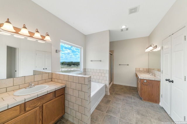 bathroom with tile patterned floors, independent shower and bath, and vanity