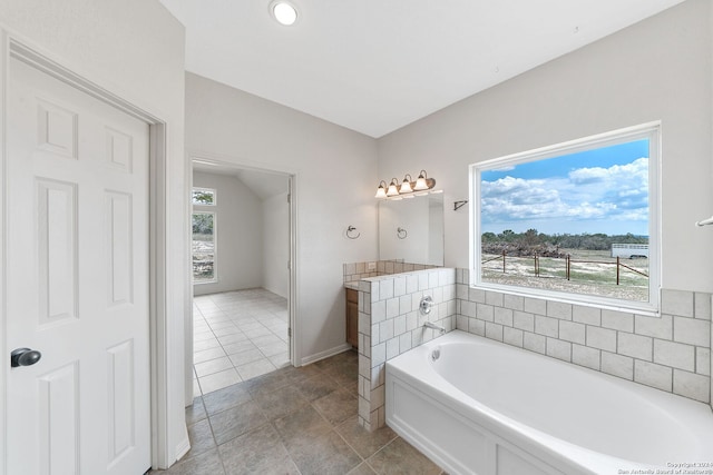 bathroom featuring a tub to relax in and vaulted ceiling