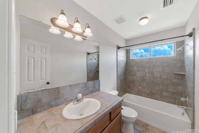 full bathroom with vanity, toilet, and tiled shower / bath