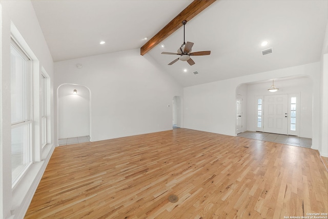 unfurnished living room with light hardwood / wood-style floors, high vaulted ceiling, beamed ceiling, and ceiling fan