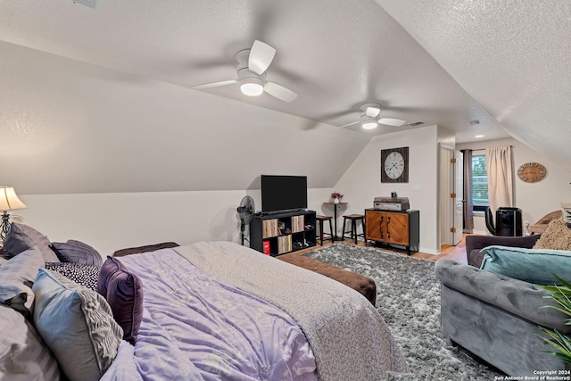 bedroom featuring a textured ceiling, ceiling fan, lofted ceiling, and hardwood / wood-style floors