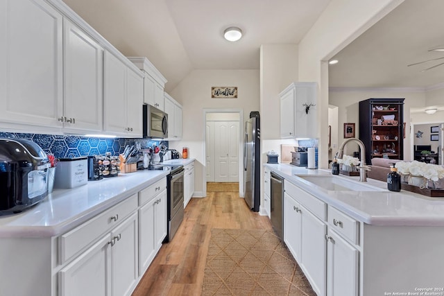 kitchen featuring light hardwood / wood-style floors, appliances with stainless steel finishes, backsplash, white cabinets, and sink