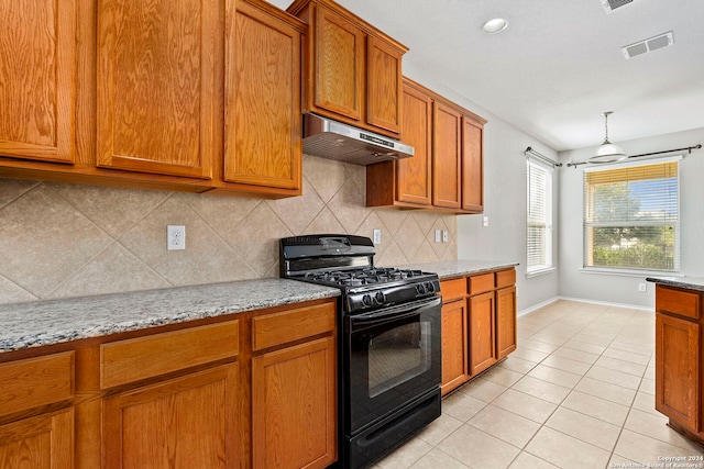 kitchen featuring stove, light stone counters, backsplash, light tile patterned flooring, and range hood