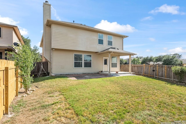 rear view of property featuring a yard and a patio area