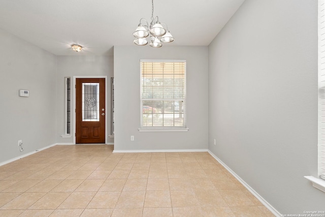 tiled entryway with a notable chandelier