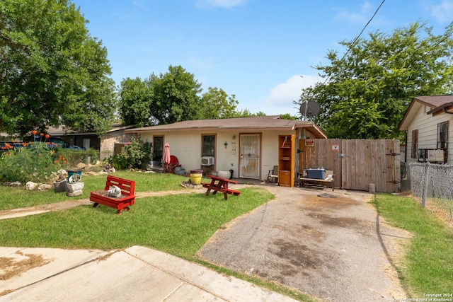 view of front of house featuring cooling unit and a front lawn