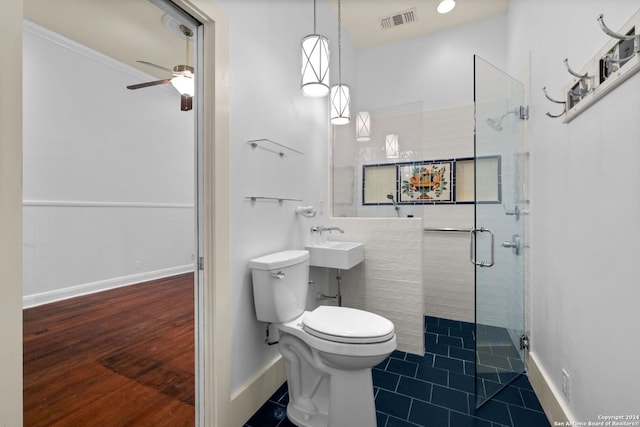 bathroom featuring tile patterned flooring, ceiling fan, a shower with shower door, toilet, and crown molding