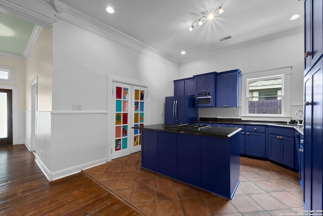 kitchen featuring a kitchen island, ornamental molding, fridge, and blue cabinets