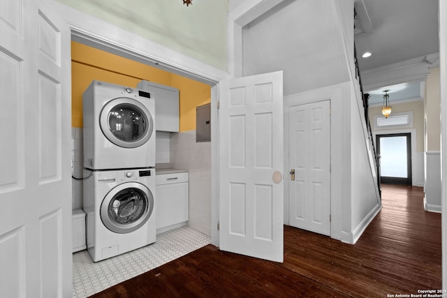 laundry room with stacked washing maching and dryer, hardwood / wood-style flooring, electric panel, and cabinets