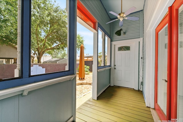 unfurnished sunroom with ceiling fan