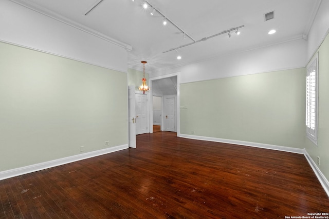 spare room with track lighting, dark hardwood / wood-style flooring, and ornamental molding