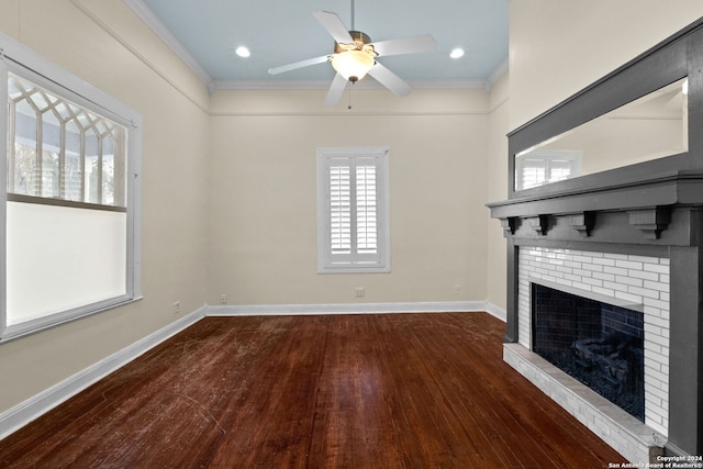 unfurnished living room with a brick fireplace, dark wood-type flooring, ceiling fan, and ornamental molding