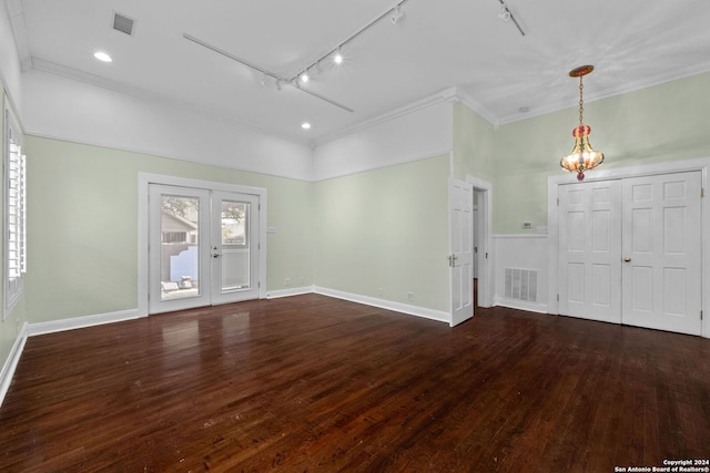 unfurnished room with french doors, ornamental molding, track lighting, a chandelier, and dark wood-type flooring