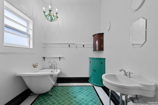 bathroom featuring sink, tile patterned floors, an inviting chandelier, and a bathtub