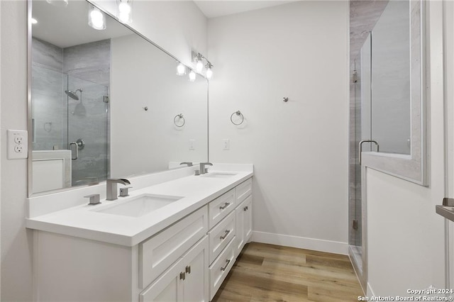 bathroom featuring hardwood / wood-style flooring, vanity, and walk in shower