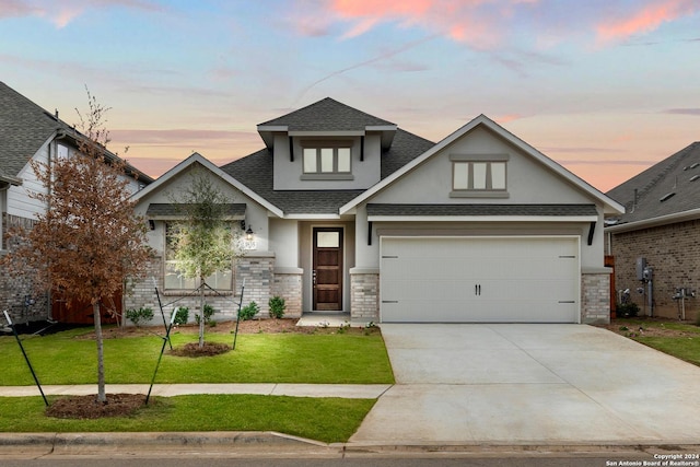 view of front of property featuring concrete driveway, brick siding, roof with shingles, and a front yard