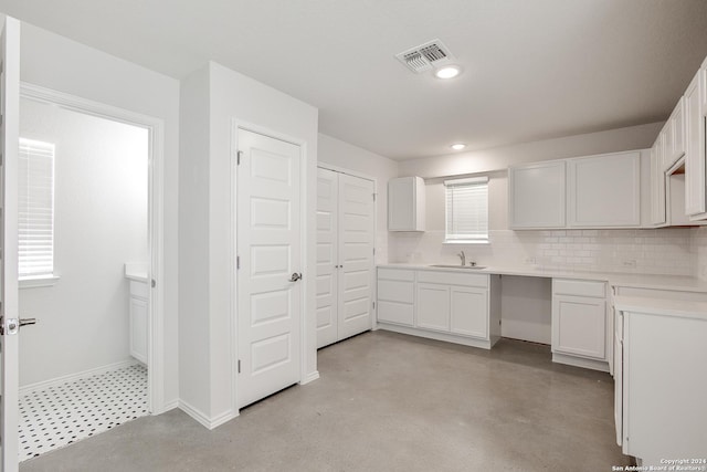 kitchen featuring decorative backsplash, white cabinets, and sink