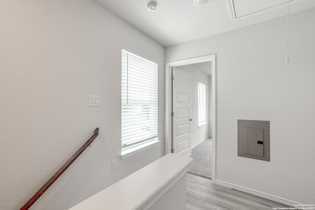 hallway with electric panel and light hardwood / wood-style floors