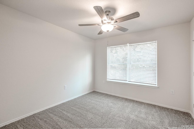 carpeted spare room featuring ceiling fan