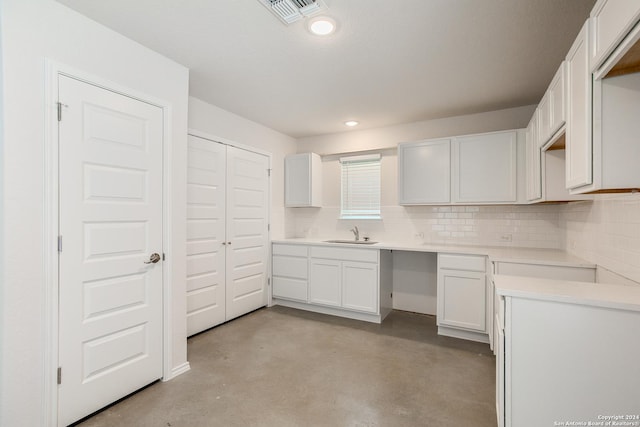 kitchen featuring decorative backsplash, white cabinets, and sink