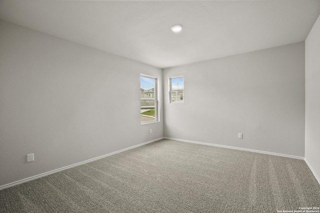 empty room featuring carpet and baseboards