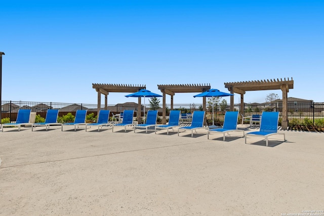 view of play area with fence, a patio, and a pergola