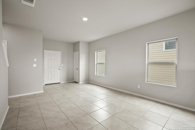 spare room featuring light tile patterned floors, baseboards, visible vents, and recessed lighting