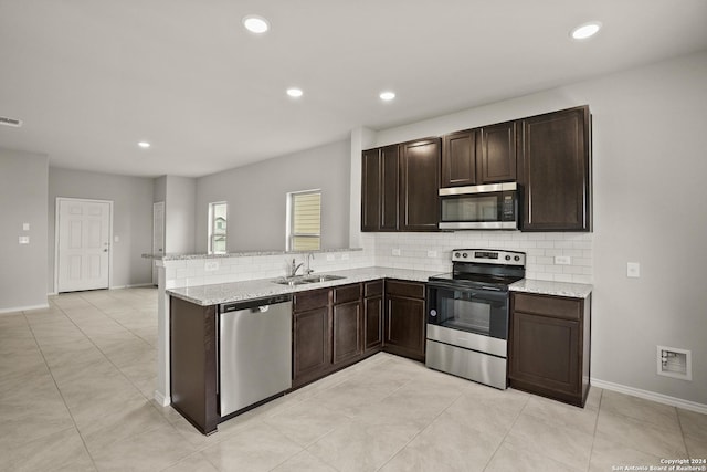 kitchen featuring dark brown cabinetry, a sink, visible vents, appliances with stainless steel finishes, and decorative backsplash