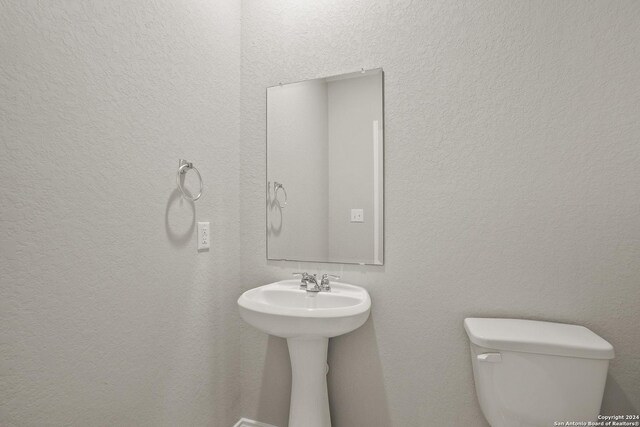 unfurnished bedroom featuring connected bathroom, a walk in closet, a closet, and light colored carpet