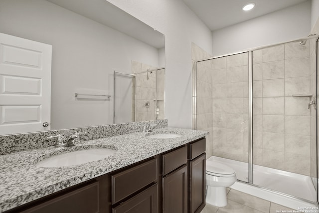 bathroom featuring tile patterned floors, vanity, toilet, and a shower with shower door