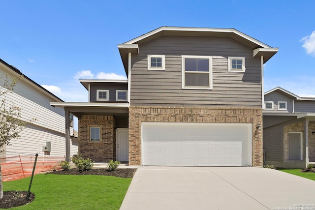 traditional-style home with fence, concrete driveway, an attached garage, a front yard, and brick siding