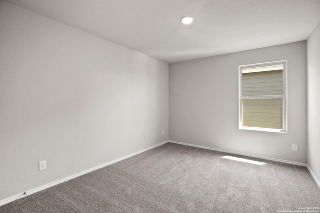 carpeted spare room with baseboards