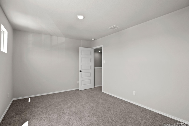 carpeted empty room featuring visible vents and baseboards