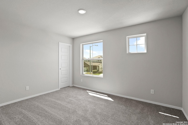 carpeted empty room with baseboards