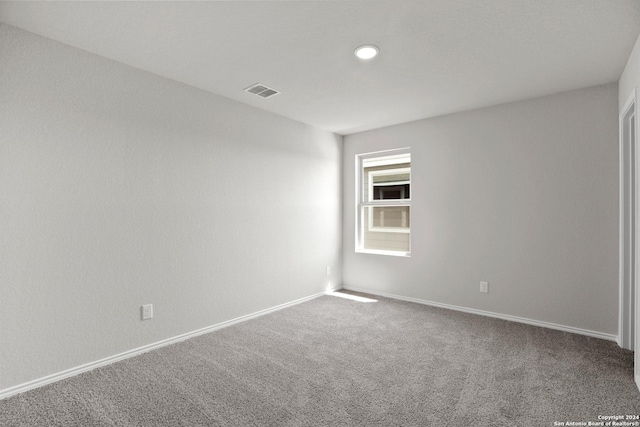 carpeted empty room featuring visible vents and baseboards