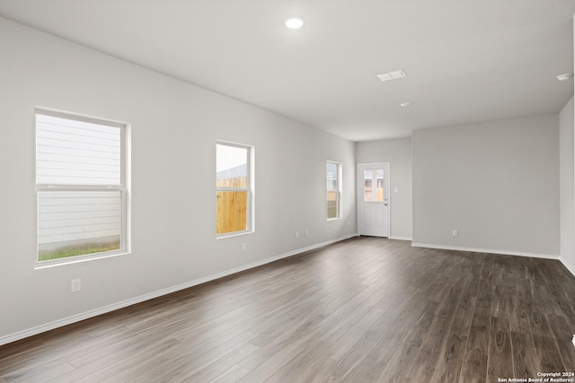 empty room featuring recessed lighting, dark wood finished floors, and baseboards