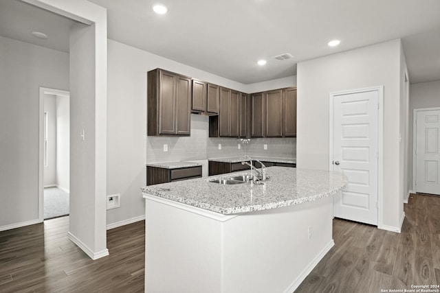 kitchen featuring tasteful backsplash, visible vents, dark wood-style flooring, dark brown cabinets, and a sink