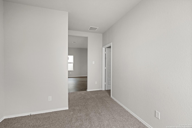 carpeted spare room featuring visible vents and baseboards