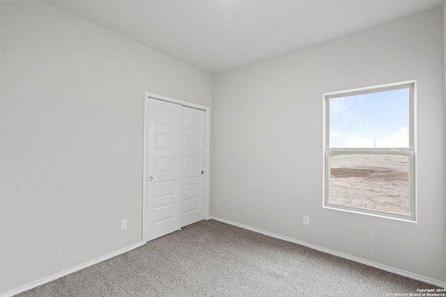 unfurnished bedroom featuring carpet floors and baseboards