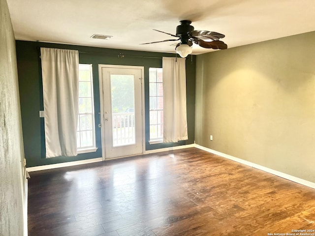 unfurnished room featuring visible vents, baseboards, wood finished floors, and a ceiling fan