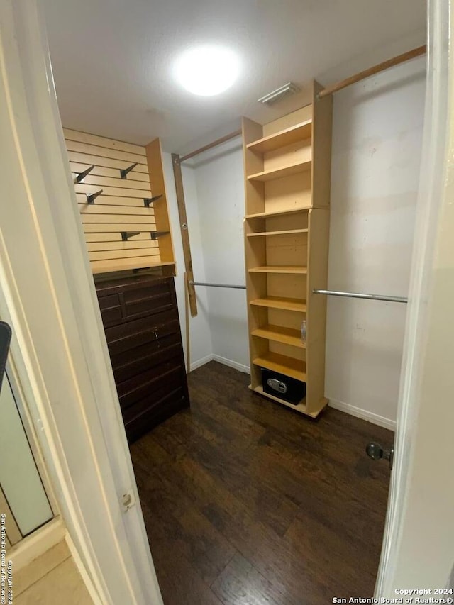 spacious closet with dark hardwood / wood-style floors