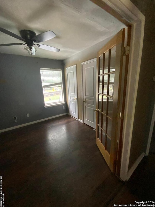 unfurnished room featuring ceiling fan and dark hardwood / wood-style floors