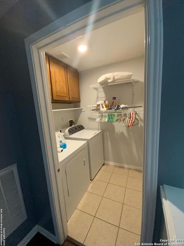 washroom with cabinets, light tile patterned floors, and independent washer and dryer