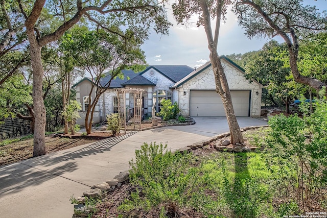 view of front of property with stone siding, an attached garage, and concrete driveway