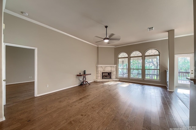 unfurnished living room featuring ceiling fan, dark hardwood / wood-style flooring, a fireplace, and plenty of natural light