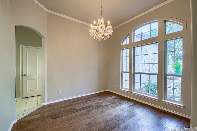 spare room featuring crown molding, a chandelier, and hardwood / wood-style floors