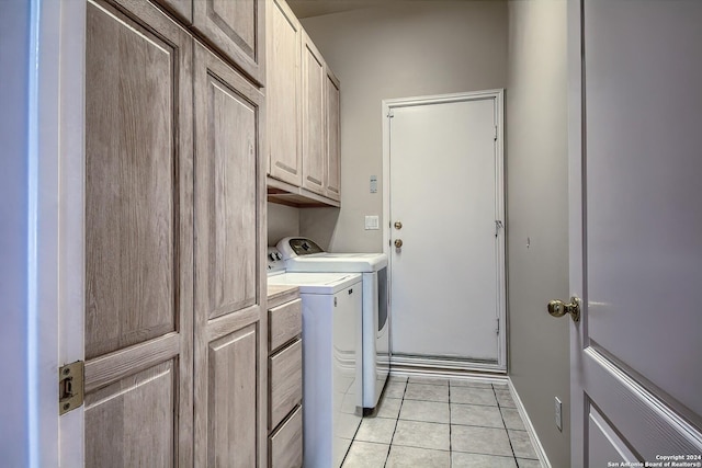 clothes washing area with cabinets, independent washer and dryer, and light tile patterned flooring